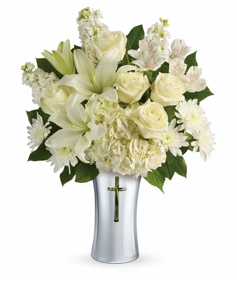 Silver cross vase filled with white hydrangea, lilies and greenery