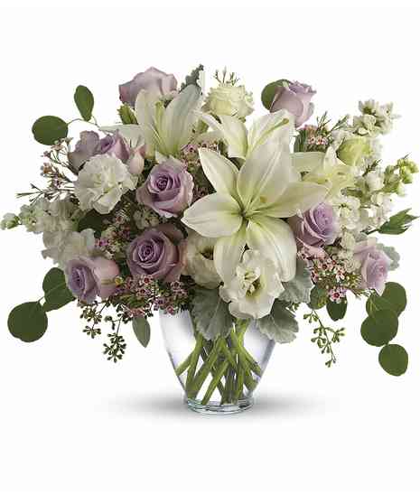 Bouquet of lavender & cream flowers in a clear glass vase