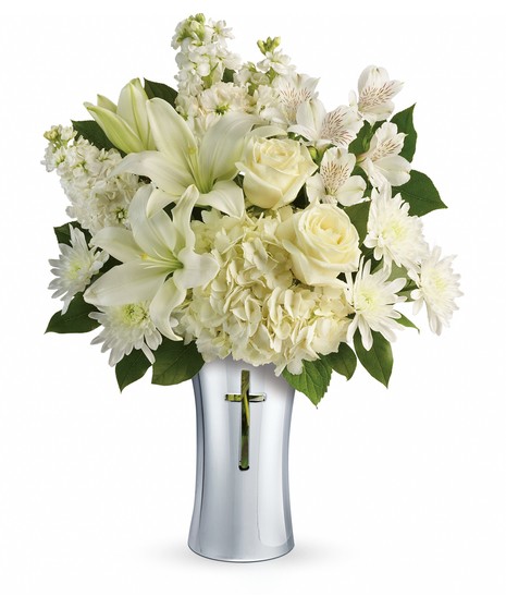 Silver cross vase filled with white hydrangea, lilies and greenery